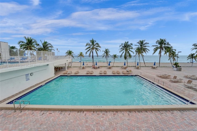 view of swimming pool with a water view and a patio