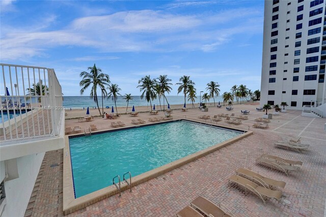 view of swimming pool with a water view and a patio area