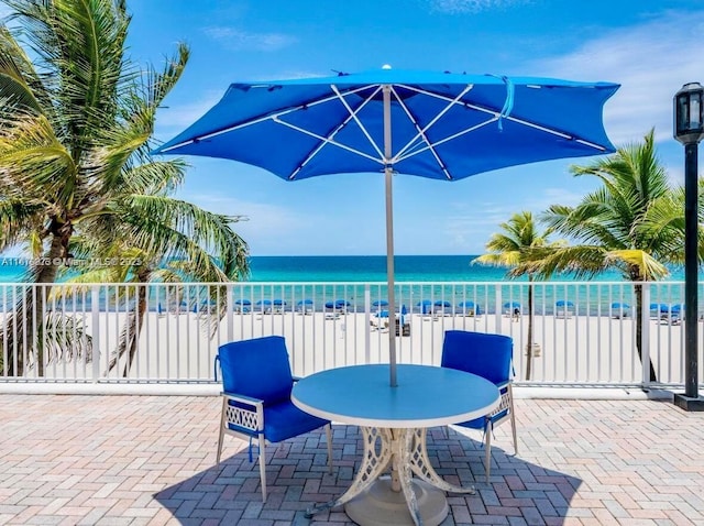 view of patio / terrace with a water view and a beach view