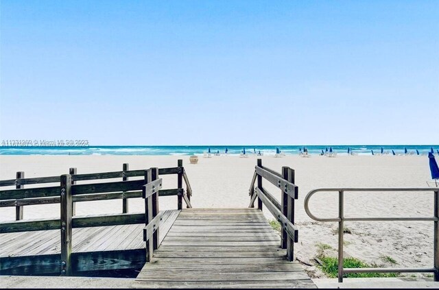 dock area with a water view and a view of the beach