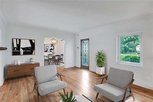 living area with ornamental molding and light wood-type flooring