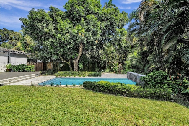 view of swimming pool with a yard