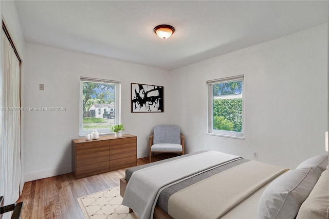 bedroom featuring light hardwood / wood-style flooring and multiple windows