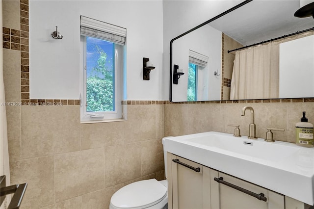 bathroom featuring tile walls, vanity, and toilet