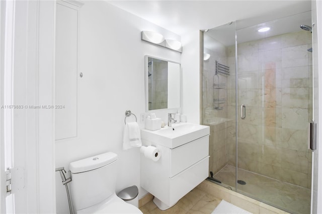 bathroom with toilet, a shower with shower door, and vanity