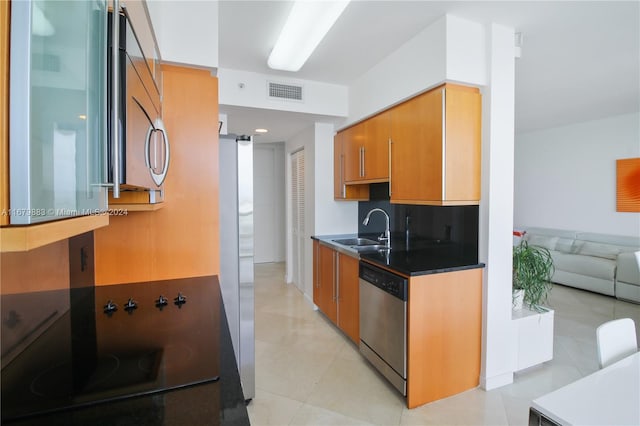 kitchen with sink, stainless steel appliances, and light tile patterned floors