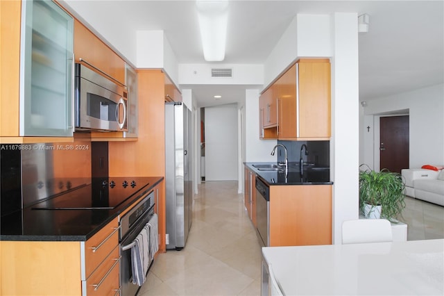 kitchen featuring decorative backsplash, stainless steel appliances, sink, and light tile patterned floors