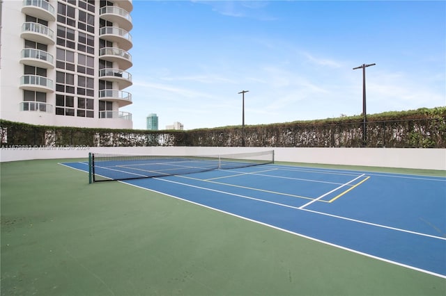 view of tennis court featuring basketball hoop