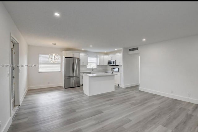 kitchen featuring white cabinets, stainless steel appliances, and a wealth of natural light