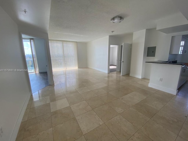 unfurnished living room featuring a textured ceiling and electric panel