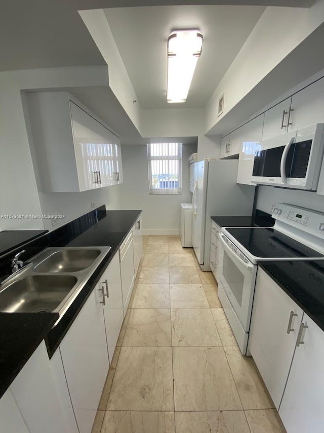 kitchen with white cabinetry, sink, and white appliances