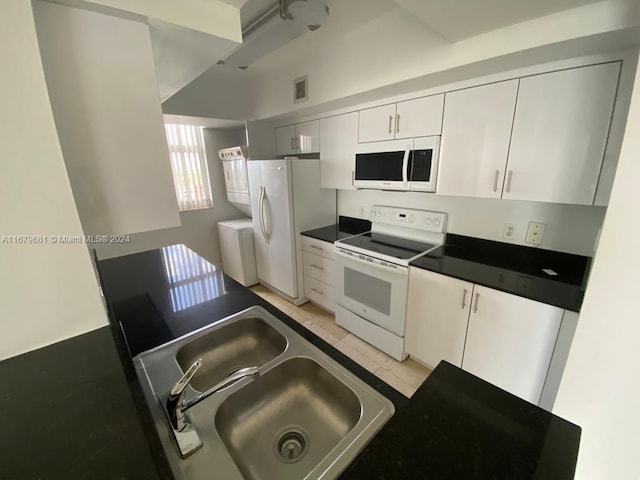 kitchen featuring white cabinetry, sink, light tile patterned floors, and white appliances