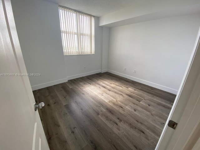 spare room with dark hardwood / wood-style flooring