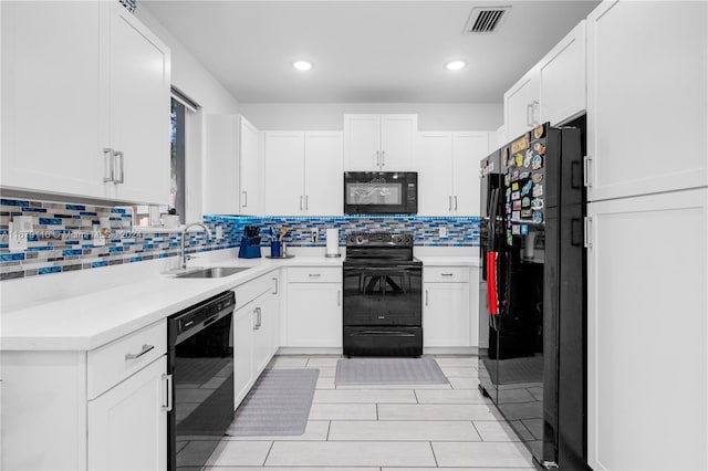 kitchen with sink, black appliances, white cabinets, and decorative backsplash