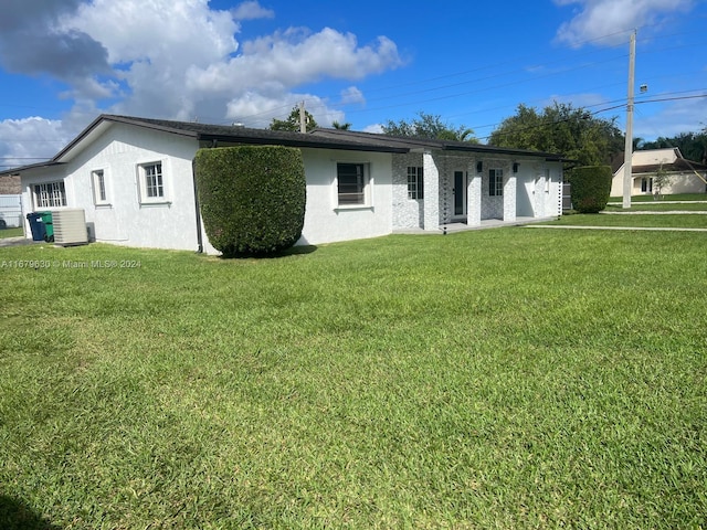 view of front of property with a front yard and cooling unit