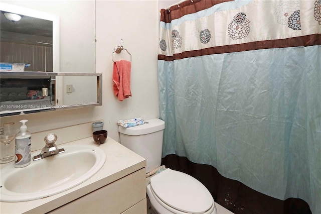 bathroom featuring vanity, toilet, and a shower with shower curtain