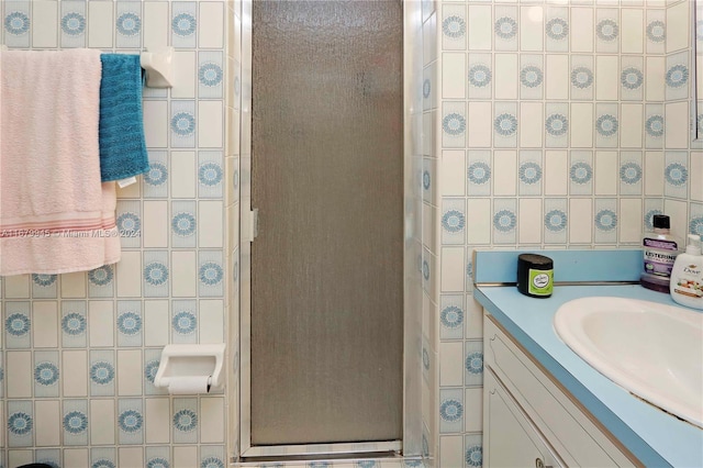 bathroom featuring tile walls, vanity, and walk in shower