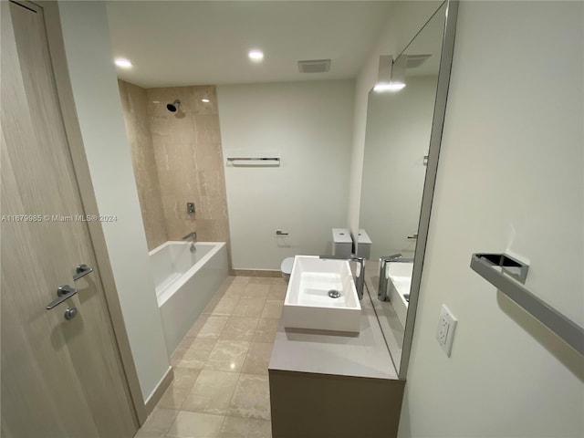 bathroom featuring vanity, tile patterned flooring, and tiled shower / bath