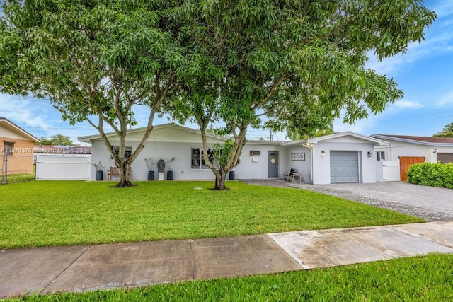 single story home featuring a front lawn and a garage