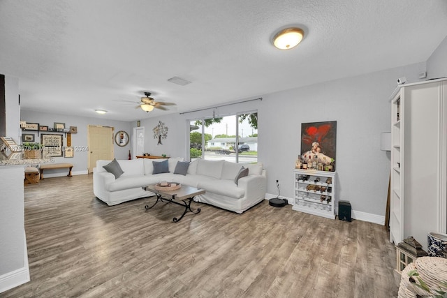 living room featuring hardwood / wood-style floors, a textured ceiling, and ceiling fan