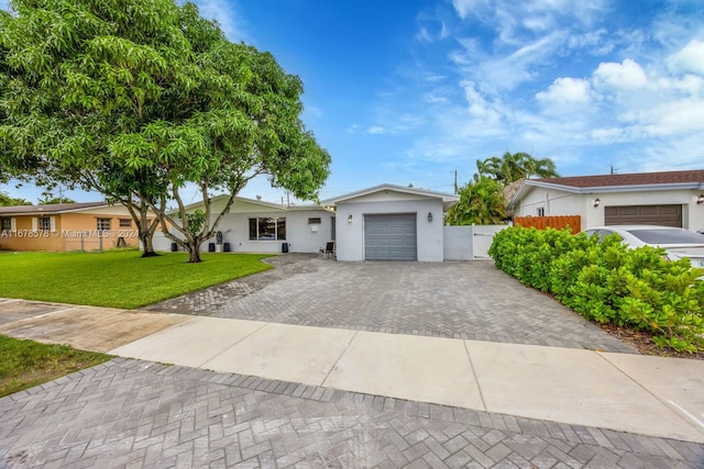 single story home with a garage and a front lawn