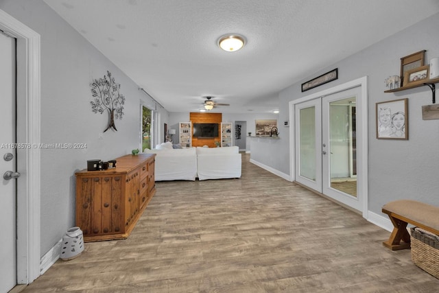 living room with french doors, wood-type flooring, a textured ceiling, and ceiling fan