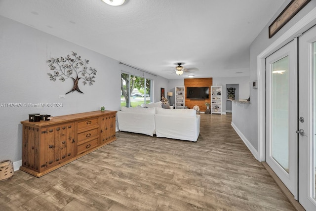 living room featuring a textured ceiling, hardwood / wood-style flooring, and ceiling fan