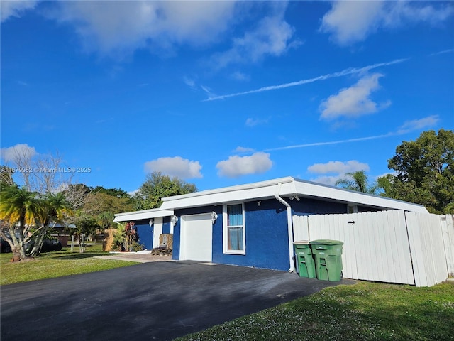 exterior space featuring a garage and a lawn