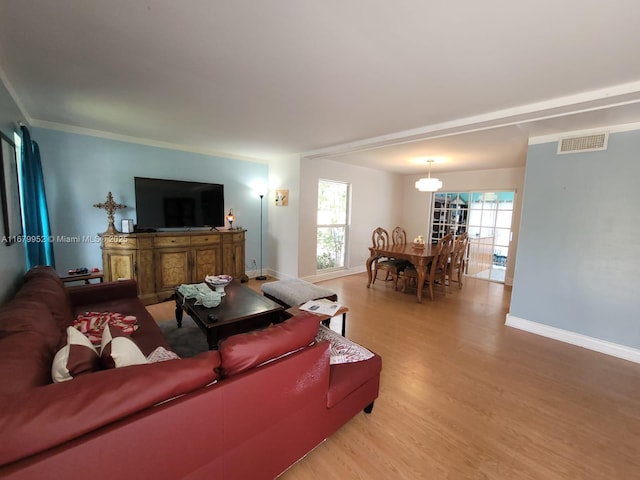 dining space with hardwood / wood-style flooring, crown molding, and beamed ceiling