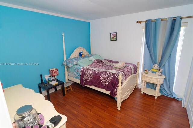 bedroom featuring hardwood / wood-style flooring and an inviting chandelier