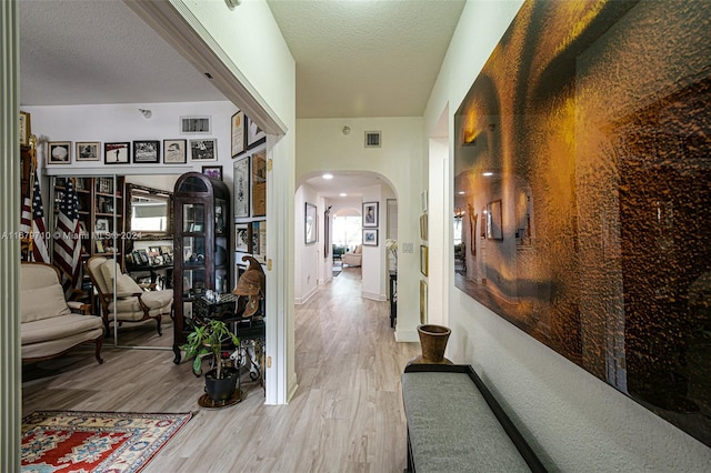 hallway with wood-type flooring and a textured ceiling