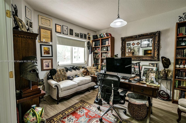 home office featuring light hardwood / wood-style flooring and a textured ceiling