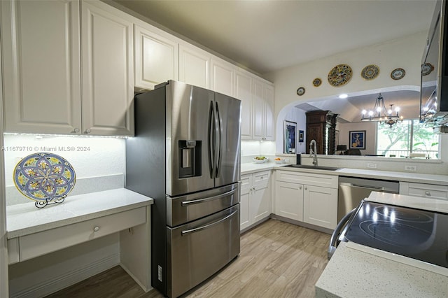 kitchen featuring an inviting chandelier, white cabinetry, light wood-type flooring, sink, and stainless steel appliances