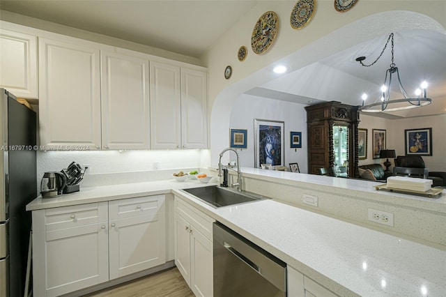 kitchen featuring sink, refrigerator, pendant lighting, stainless steel dishwasher, and white cabinets