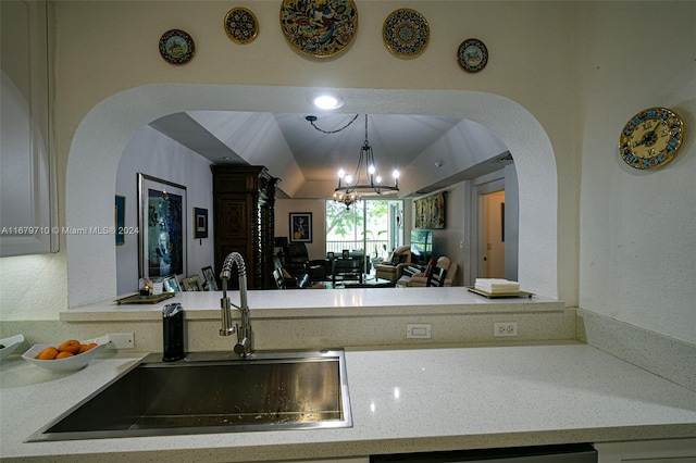 kitchen featuring lofted ceiling, decorative light fixtures, a chandelier, and sink