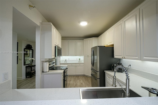 kitchen featuring white cabinetry, light hardwood / wood-style flooring, and stainless steel appliances