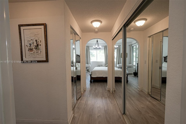 hall featuring a textured ceiling and light wood-type flooring