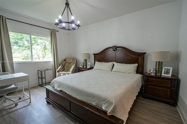 bedroom with an inviting chandelier and dark hardwood / wood-style floors