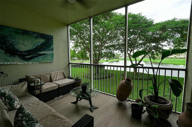 sunroom / solarium featuring a water view and ceiling fan