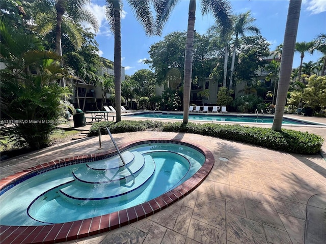 view of swimming pool with a patio area and a community hot tub