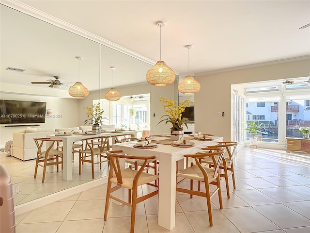 dining area featuring ceiling fan, light tile patterned floors, and crown molding