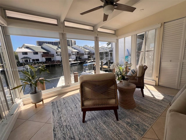 sunroom with ceiling fan, plenty of natural light, and a water view