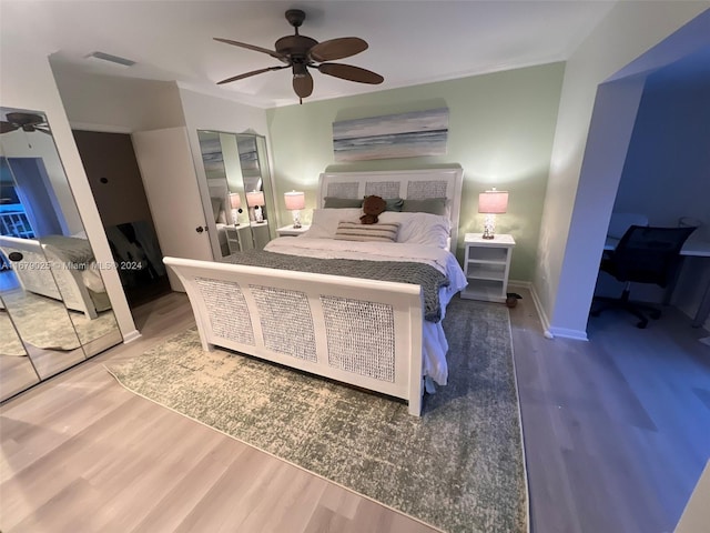 bedroom with ceiling fan, crown molding, and hardwood / wood-style flooring