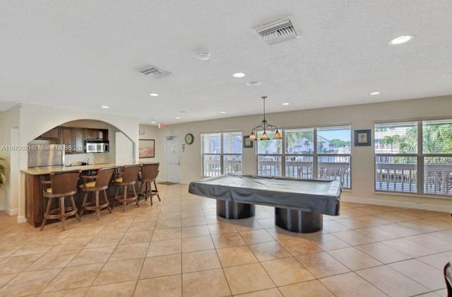 recreation room with light tile patterned floors, a textured ceiling, and pool table