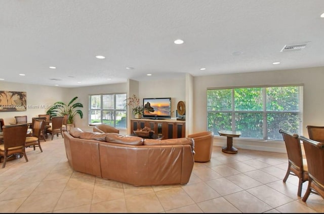 living room featuring plenty of natural light, light tile patterned flooring, and a textured ceiling