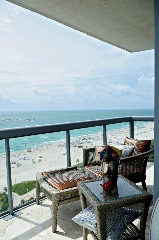 balcony with a water view and a beach view