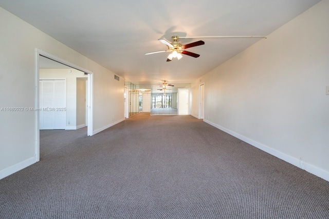 unfurnished living room featuring dark carpet and ceiling fan