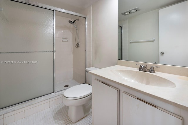 bathroom with a shower with door, vanity, tile patterned floors, and toilet