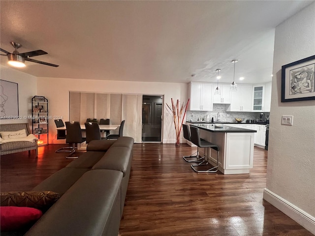 living room with sink, dark wood-type flooring, and ceiling fan