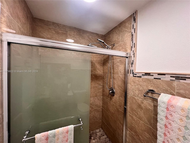 bathroom featuring a shower with door